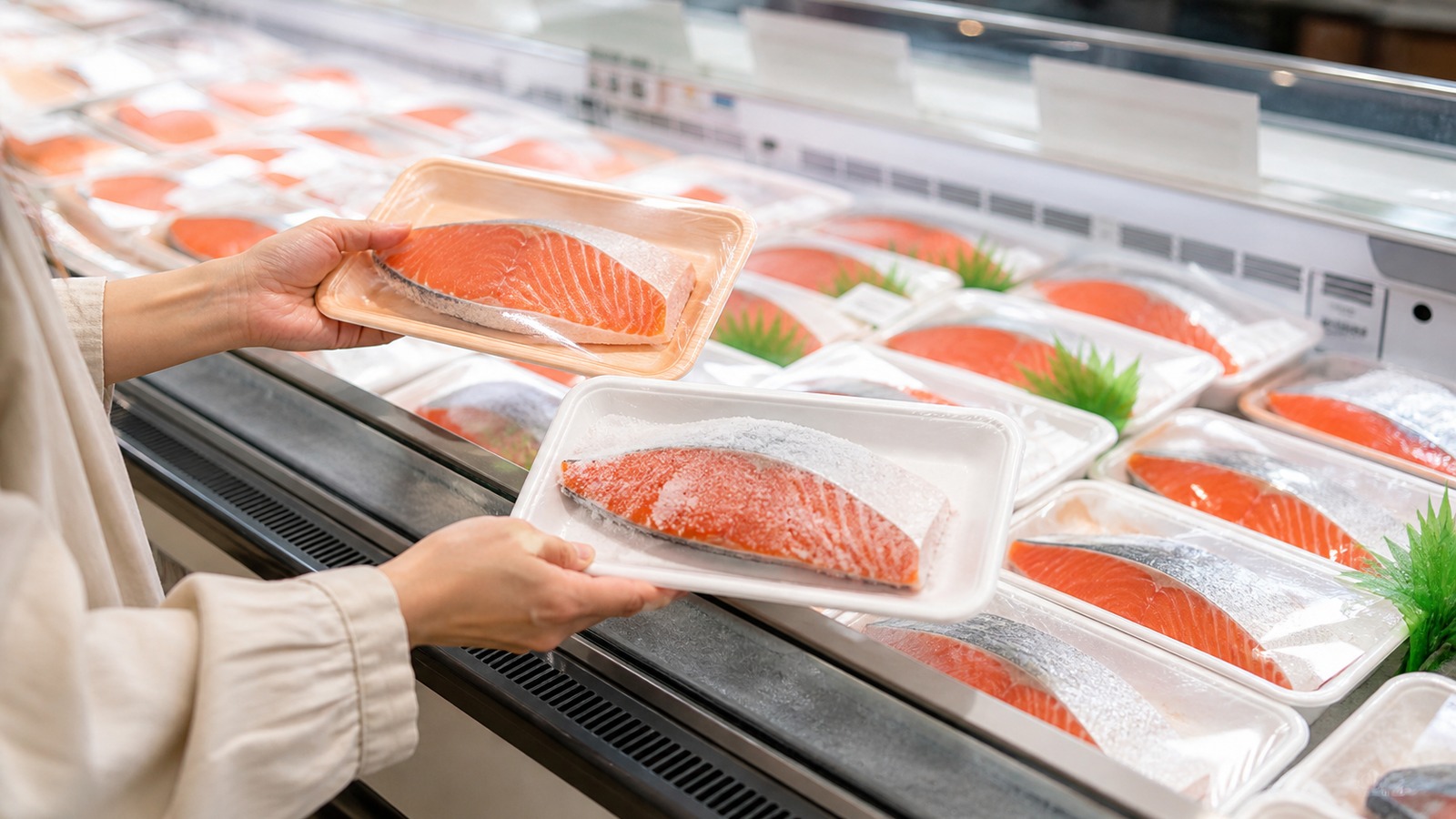 スーパーの鮮魚売場で塩鮭や紅鮭の切り身を探している様子、商品名が見やすい横長の実用イメージ